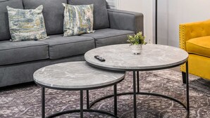 A modern living room with a grey sofa, two round tables, a yellow armchair, and a floor lamp. - Chic Modern Stay w Patio Near LA Best Sights6 (Altadena)