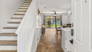 A staircase with wooden steps and white railings leading to a room with a view of a pool. - Gulf Highlands escape - pool and beach access (Panama City Beach)