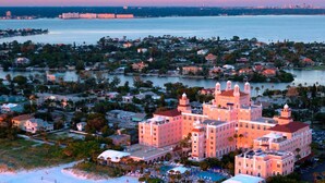 Un gran complejo turístico con varias edificaciones, frente a la playa y un puerto deportivo.