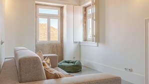 Ein modernes Wohnzimmer mit hoher Decke, großem Fenster und einem grünen Sitzsack.