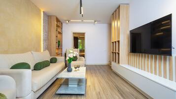 A modern living room with a sofa, coffee table, and TV.