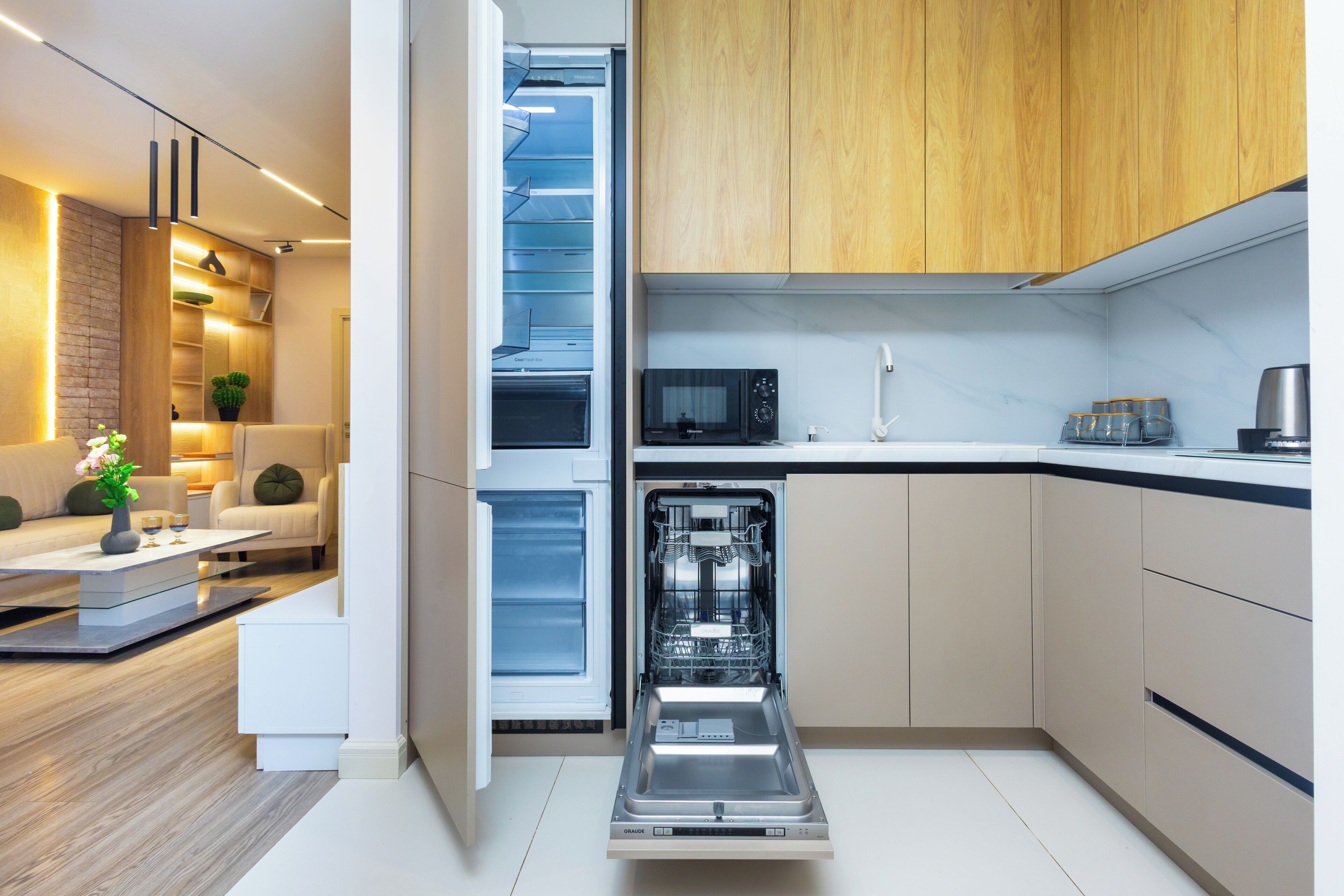 A modern kitchen with a dishwasher, microwave, and wooden cabinets.
