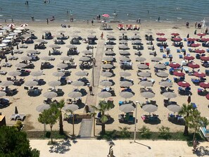 Playa privada, playa de arena blanca y camastros 