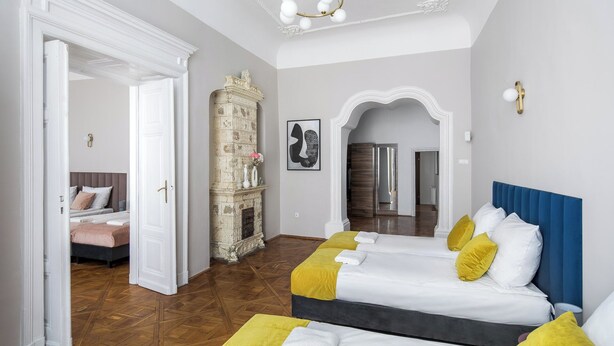A hotel room with two beds, a fireplace, and a mirror.