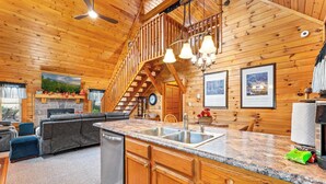 L’intérieur d’une cabane en bois comprend une cuisine, un coin repas et un salon.