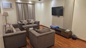 Suite – deluxe, 2 soverom | Oppholdsområde | En 32-tommers TV med Parabol-TV