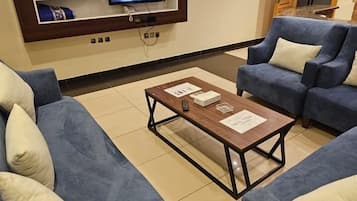 Deluxe Suite, 2 Bedrooms | Living area | 32-inch TV with satellite channels