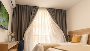 A hotel room with a bed, a desk, and a chair. - RM Campana Hotel (Campana)