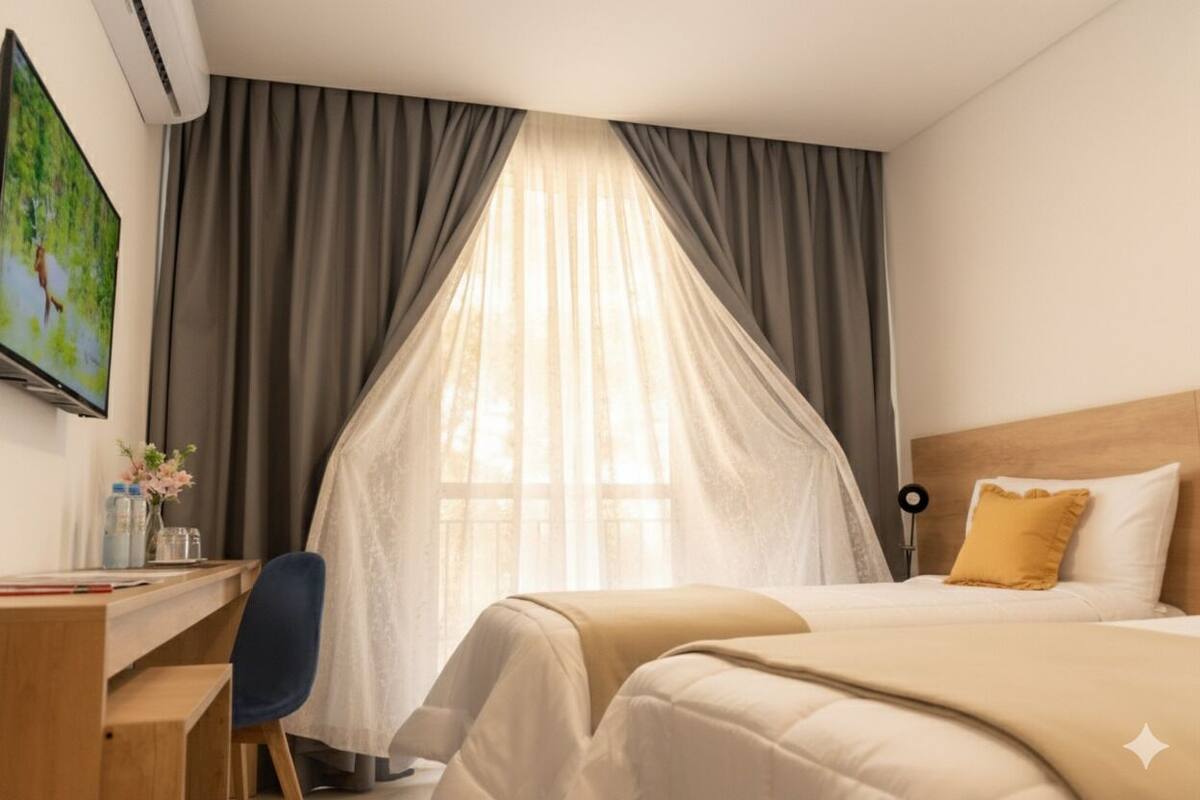 Una habitación de hotel con una cama, un escritorio y una silla.