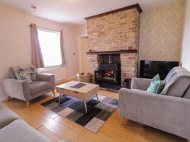 A living room with a fireplace, two sofas, a coffee table, and a television.