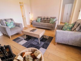 A living room with two grey sofas, a wooden coffee table, and a black and grey rug.