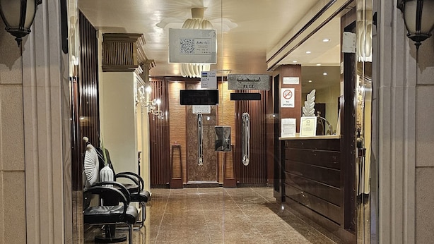 A hotel entrance with a marble floor, a reception desk, and a sign indicating full parking. - Abha lamar for serviced apartments (Riyadh)