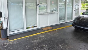 Un bâtiment doté de grandes fenêtres et d’un espace d’entrée abrité.