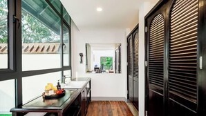 A hallway with a wooden floor, a glass door, and a view of the outdoors. - Fu Er Man Hotel (Luang Prabang)
