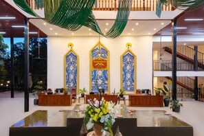 A reception area with a reception desk, a water feature, and decorative panels. - Fu Er Man Hotel (Luang Prabang)