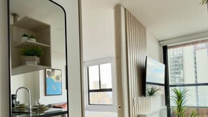 Un appartement moderne comprenant une cuisine, un coin repas et une chambre.