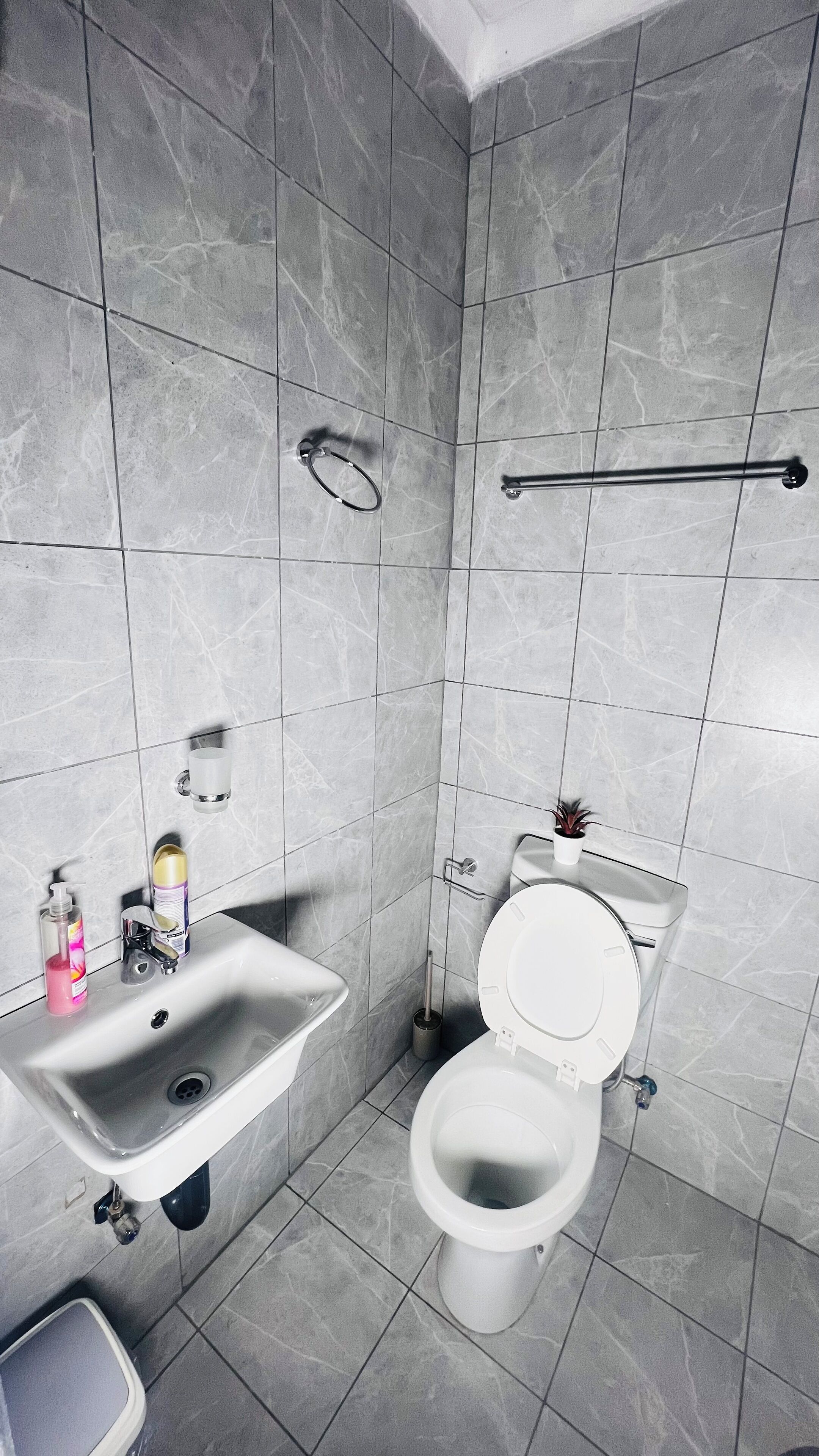 A modern bathroom with a sink, toilet, and hand dryer.