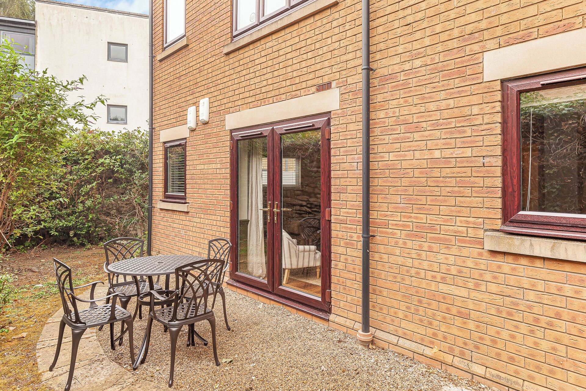 A brick building with a patio area featuring a table and chairs.