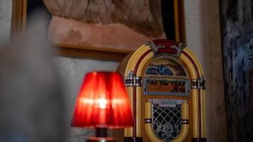 A vintage radio with a red lamp in front of a stone sculpture.