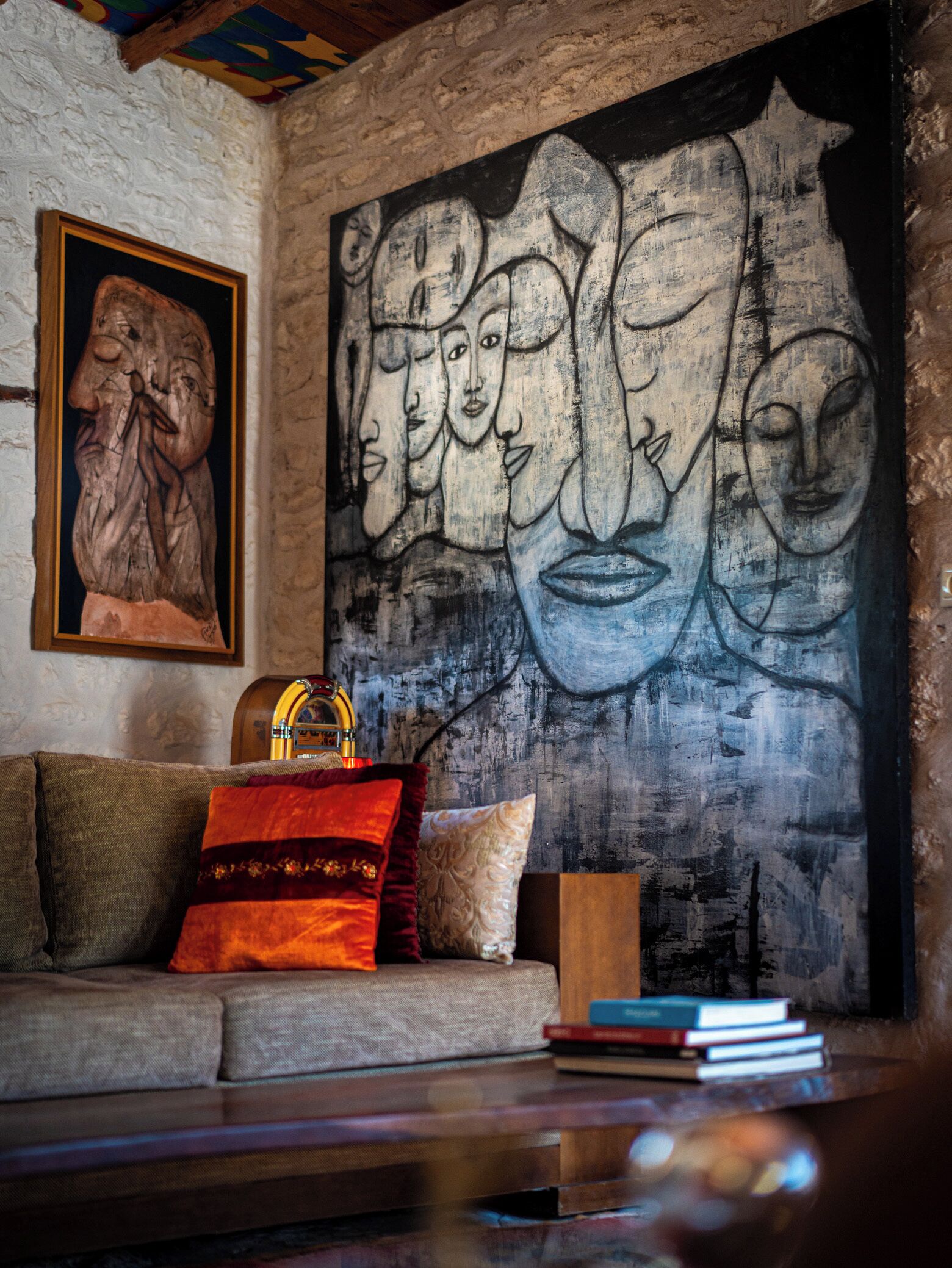A cozy living room with a textured wall, a wooden coffee table, a sofa with cushions, and a framed artwork above the sofa.