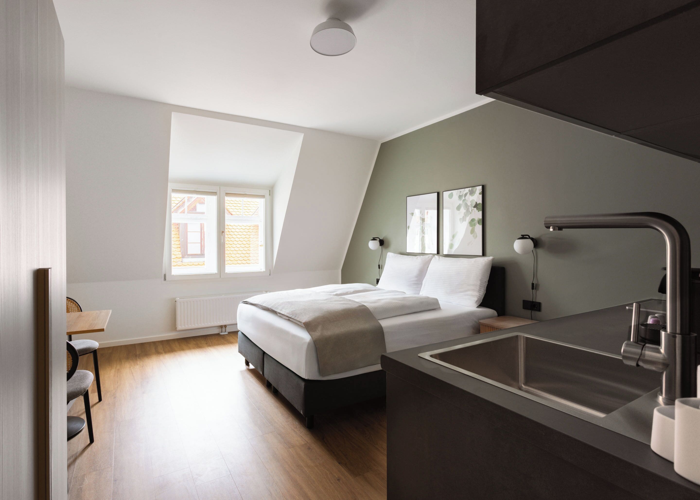 Une chambre à coucher moderne avec un lit, une table de chevet et un lavabo intégré.