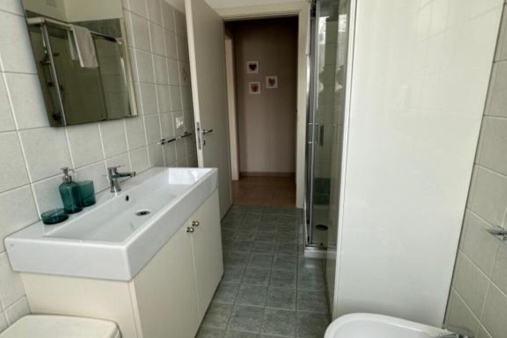 Ein Badezimmer mit Waschbecken, Spiegel und Dusche.