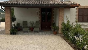 A covered outdoor seating area with chairs and potted plants. - Tourist Location A Casa di Viola: 1 Bedroom House (Orvieto)