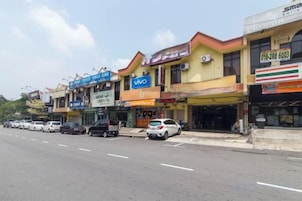 A street with multiple storefronts, including a 7-Eleven and a Viva store.