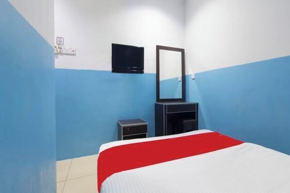 A hotel room with a bed, a TV, a mirror, and a small cabinet. - Mines Cempaka Budget Hotel (Nilai)