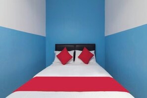 A single bed with a black headboard, white bedding, and two red pillows. - Mines Cempaka Budget Hotel (Nilai)
