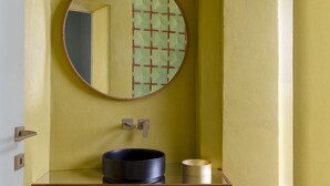 A bathroom with a round mirror, a sink, and a toilet. - The Wheels Florence Bed&Breakfast Superior Bedroom MENTA (Florence)
