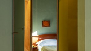 A room with a bed, a nightstand, and a wall-mounted picture. - The Wheels Florence Bed&Breakfast Superior Bedroom MENTA (Florence)