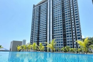 A high-rise hotel with a swimming pool in front. - JQ PREMIER SUITES T1 L07 (Kota Kinabalu)