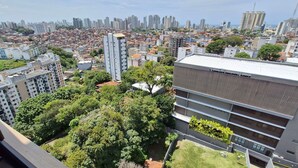 A high-rise building with multiple floors, surrounded by greenery and other residential buildings. - COFDR0104 - Edifício House Federação (Salvador)