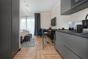 Une chambre d’hôtel moderne dotée d’une kitchenette, d’un coin repas et d’un lit avec vue.