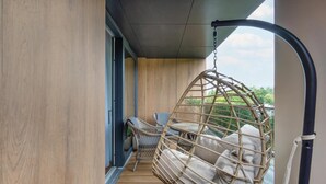A balcony with a hanging chair and two wicker chairs. - Holiday studio with balcony, indoor pool, sauna (Polanica Zdroj)