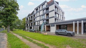 A multi-story building with a modern architectural design, featuring balconies and large windows. - Holiday studio with balcony, indoor pool, sauna (Polanica Zdroj)