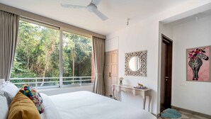 A bedroom with a large bed, a desk, and a view of the outdoors. - 2BHK Apartment in North Goa , Reis Magos, Near Candolim (Verem)