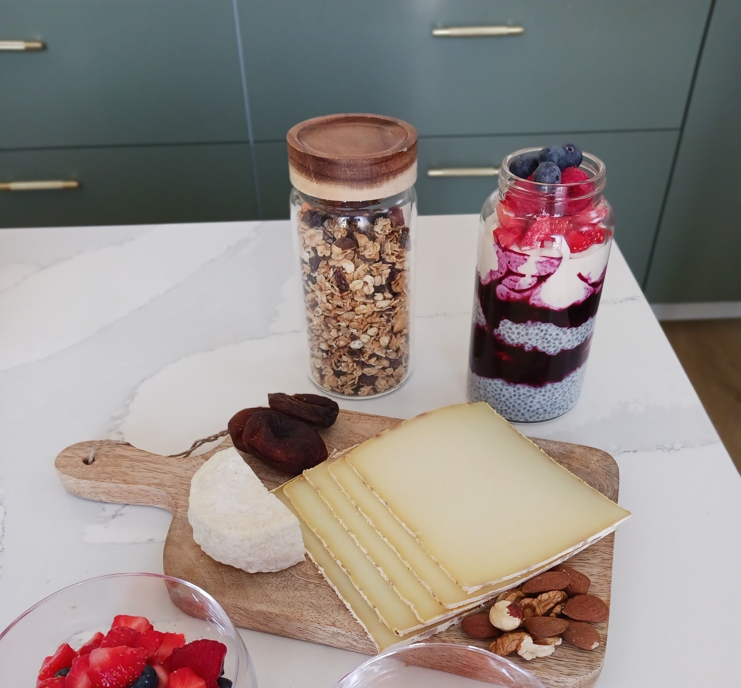 A wooden board with cheese, dried fruits, and nuts.