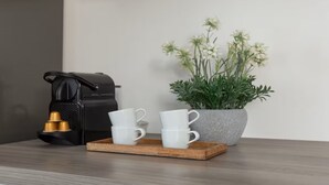 A coffee maker, white cups, and a potted plant on a wooden tray. - 8th floor - Milano view (Milan)