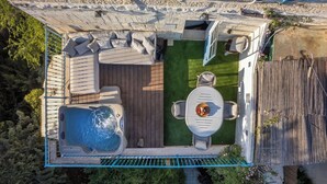 An aerial view of a backyard with a hot tub, a wooden deck, and a seating area with a table and chairs. - Timeless Charm, Stunning Views & Serene Comfort (Jerusalem)