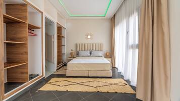 Ein Schlafzimmer mit Bett, Nachttischen, einem Kleiderschrank und einer Deckenleuchte.