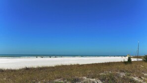 Ein Strand mit blauem Himmel und sandigem Ufer.