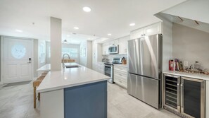 A modern kitchen with a central island, stainless steel appliances, and a bright, well-lit space.