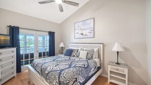 A bedroom with a bed, a dresser, a nightstand, a ceiling fan, and a window with curtains. - Heated Pool, FREE WIFI Luxury Bayside Condo Across from Siesta Key Beach |  Beautiful 3BR/2BA Gulf & Bay Club Bayside Condo (Sarasota)
