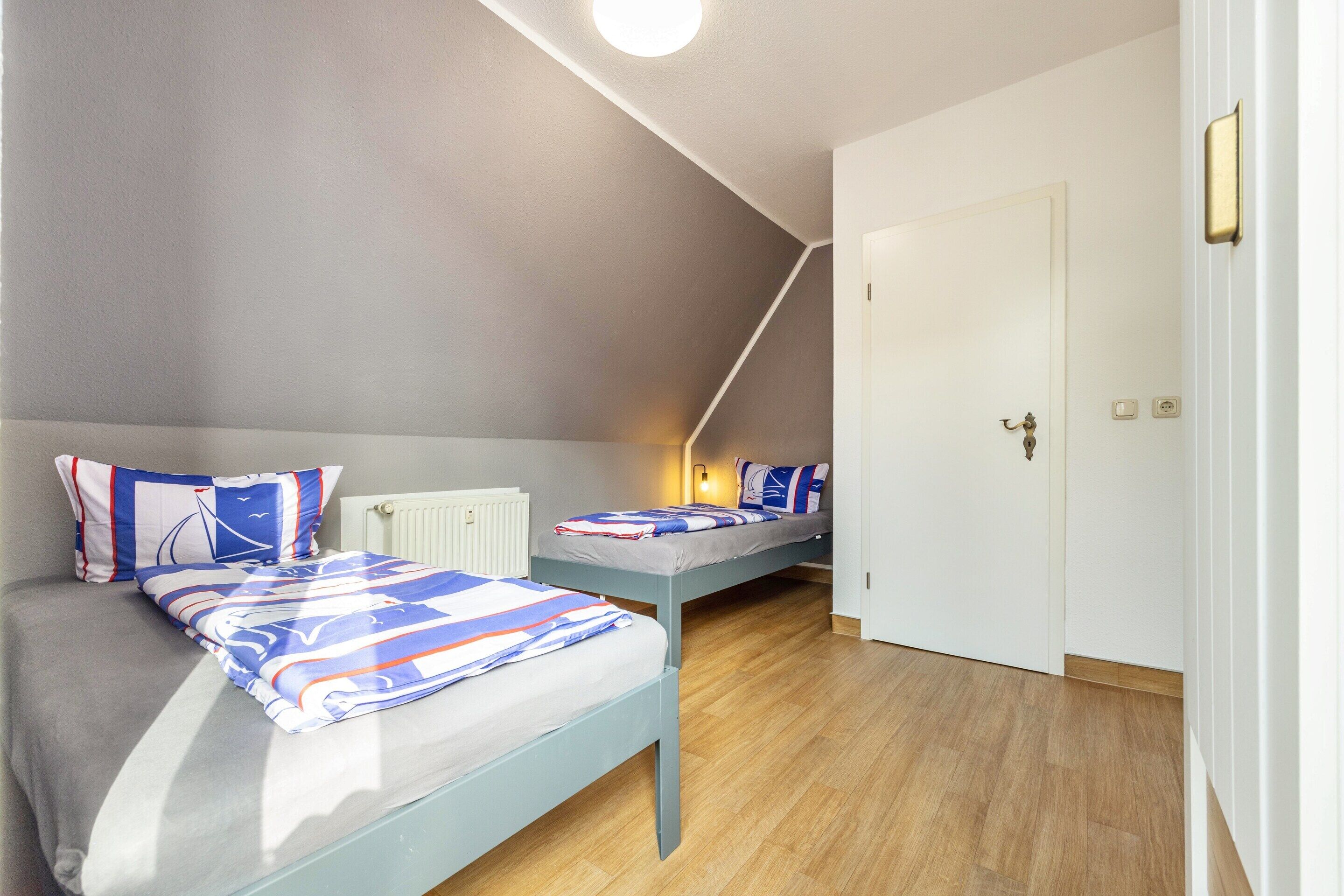 Un dormitorio con dos camas, un radiador y una puerta.