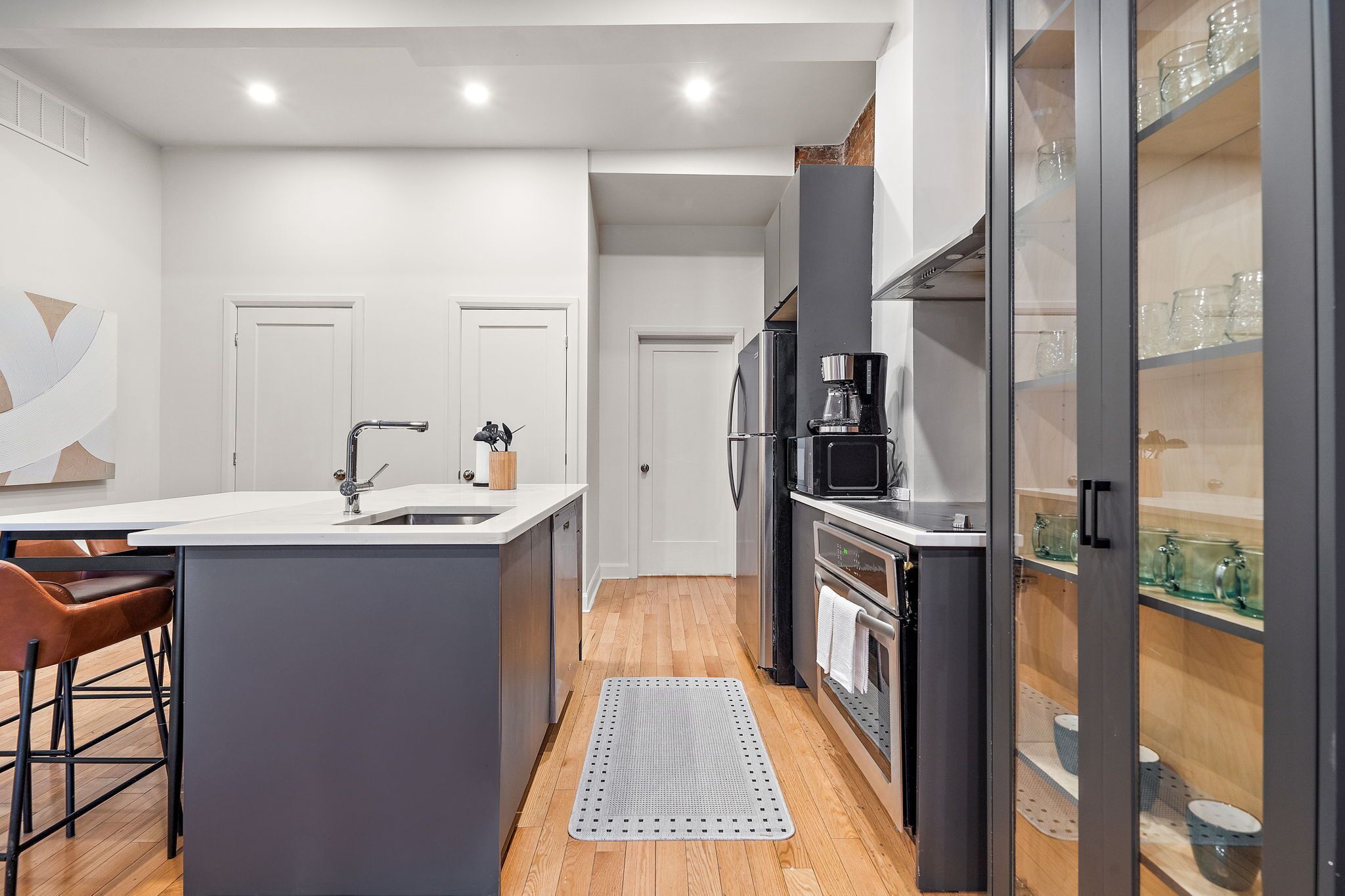 Una cocina moderna con una isla central, un microondas y una cafetera.