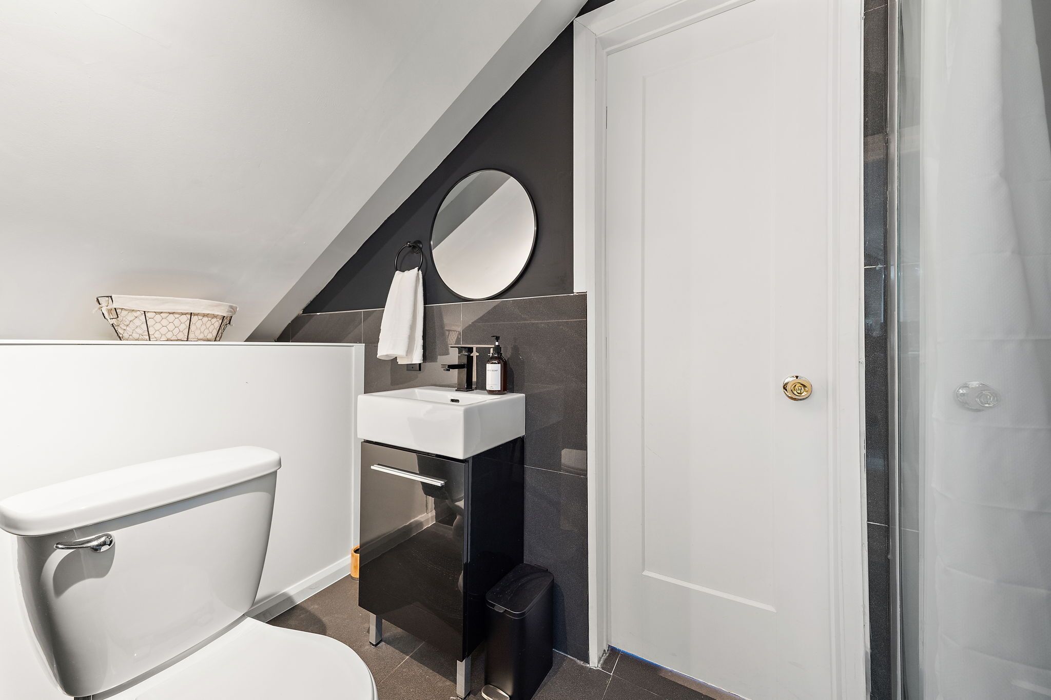 Een moderne badkamer met toilet, wastafel en spiegel.