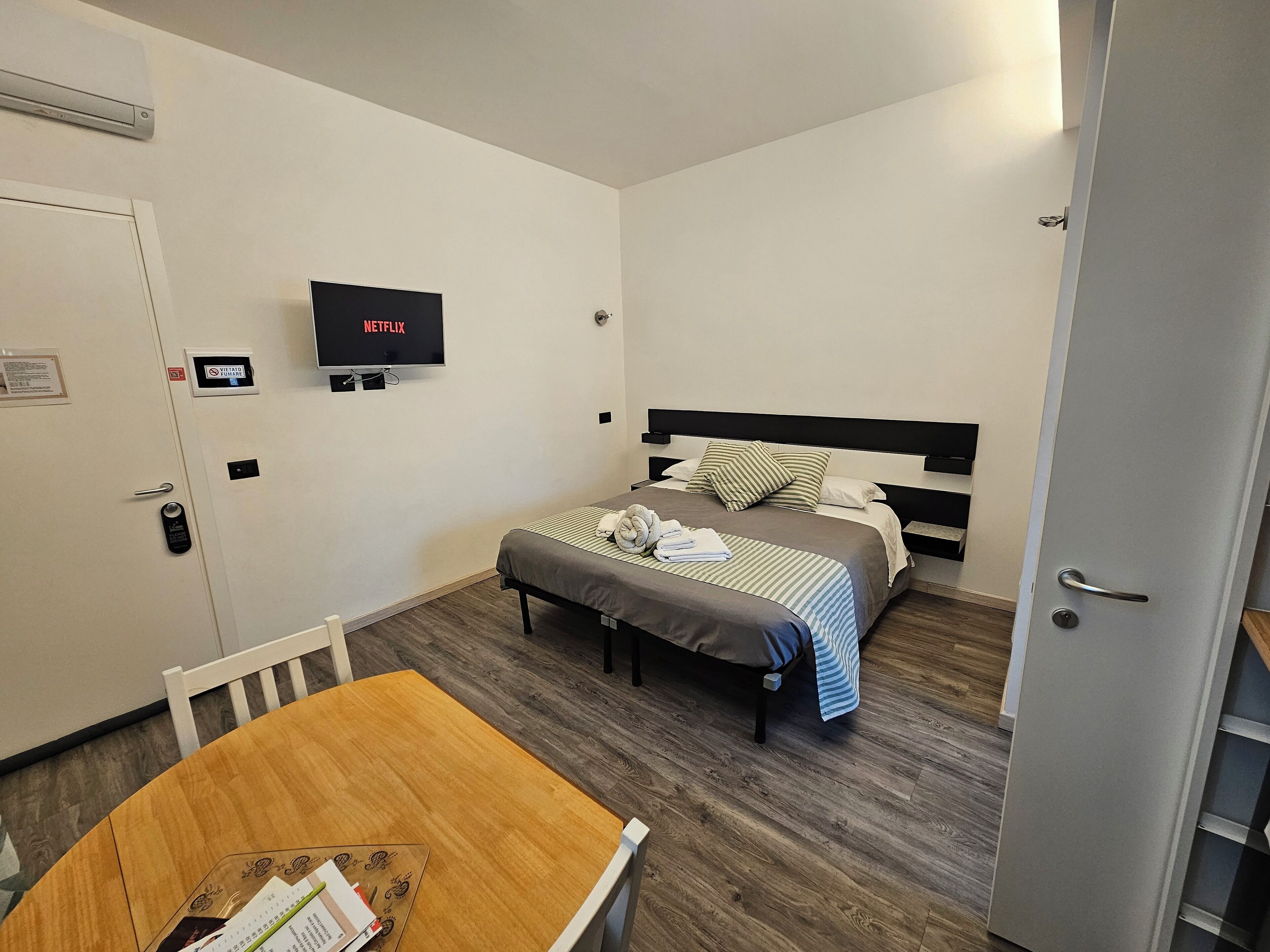 Ein Hotelzimmer mit Bett, Fernseher, Schreibtisch und Stuhl.