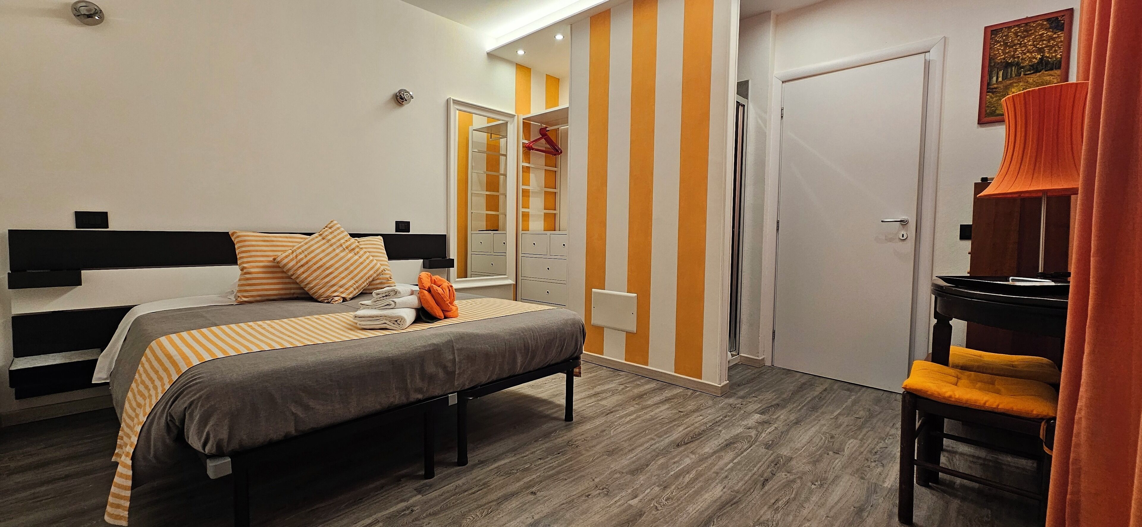 A bedroom with a bed, bedside table, and a wardrobe.